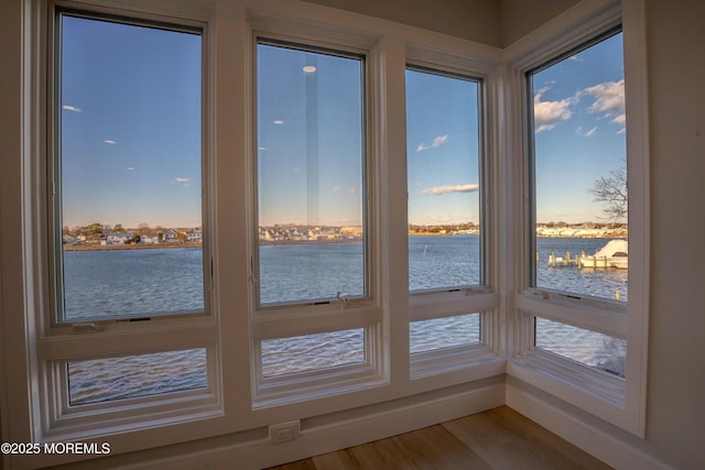 unfurnished sunroom featuring a water view