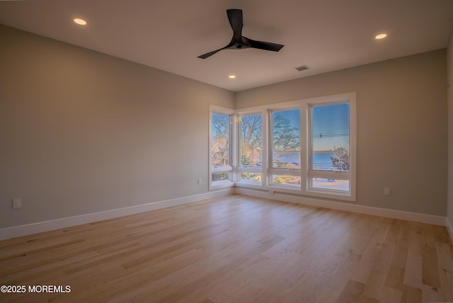 unfurnished room with ceiling fan and light wood-type flooring