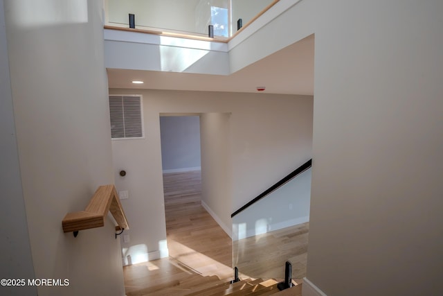 stairs featuring hardwood / wood-style floors and a towering ceiling