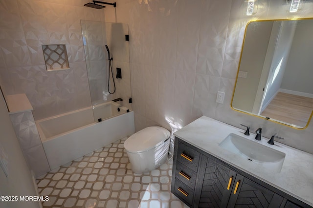 full bathroom featuring tile walls, vanity, toilet, and tiled shower / bath