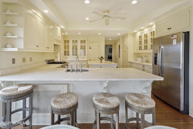 kitchen with appliances with stainless steel finishes, sink, a kitchen bar, and kitchen peninsula