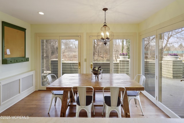 dining area featuring hardwood / wood-style flooring and a chandelier