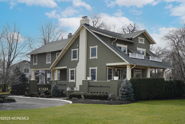 view of front facade with a balcony and a front lawn