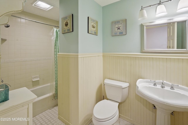 full bathroom featuring sink, shower / tub combo, tile patterned flooring, toilet, and wood walls