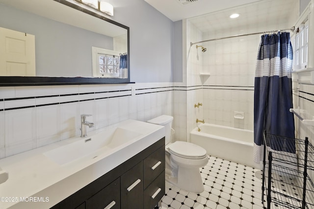 full bathroom with toilet, tile walls, vanity, shower / bathtub combination with curtain, and a healthy amount of sunlight