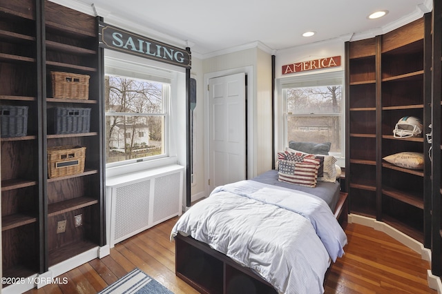 bedroom with radiator, wood-type flooring, and ornamental molding