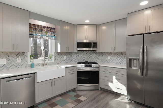 kitchen featuring stainless steel appliances, tasteful backsplash, sink, and gray cabinets