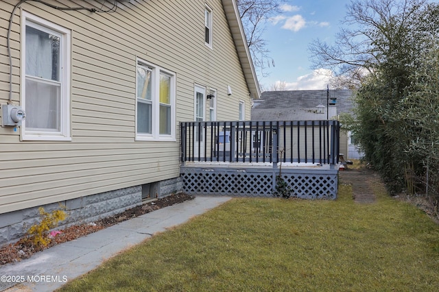 view of side of home featuring a wooden deck and a lawn