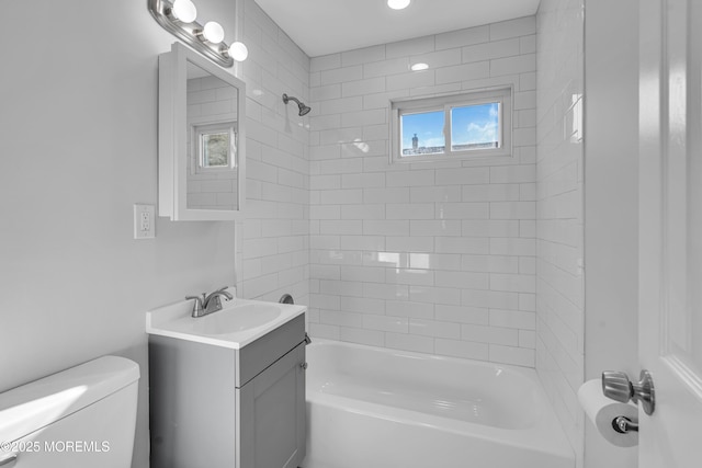 full bathroom with vanity, tiled shower / bath combo, toilet, and a healthy amount of sunlight