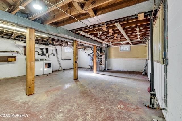 basement with washing machine and clothes dryer and heating unit