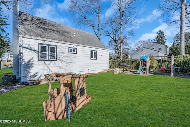 rear view of house with a playground and a yard