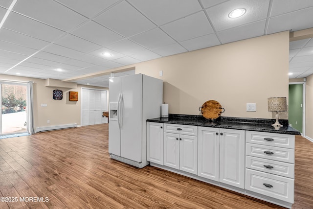 9 Mehar Ct, Jackson, NJ 08527 - kitchen with white fridge with ice dispenser, a baseboard radiator, a drop ceiling, white cabinetry, and light wood-style flooring