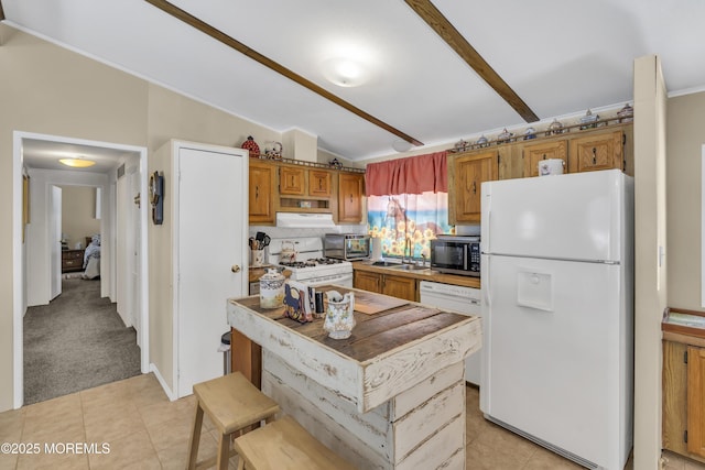 kitchen featuring vaulted ceiling, backsplash, a center island, light colored carpet, and white appliances