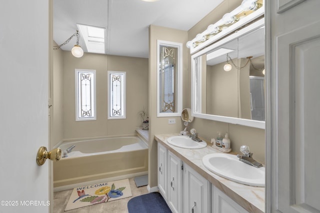 bathroom with vanity, a tub, tile patterned floors, and a skylight