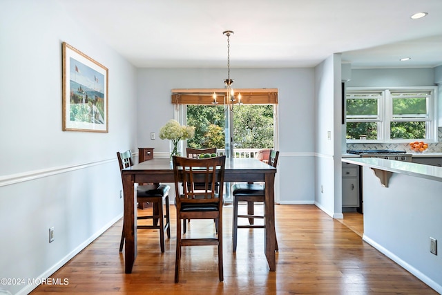 dining room with recessed lighting, a notable chandelier, baseboards, and wood finished floors