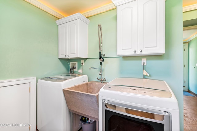 laundry room featuring a sink, washing machine and clothes dryer, cabinet space, and crown molding