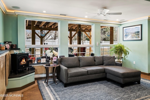 living room with a wood stove, ceiling fan, crown molding, and recessed lighting