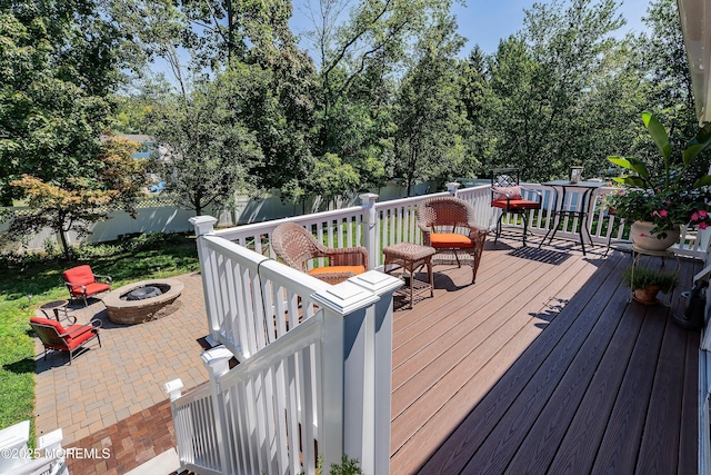 wooden terrace featuring an outdoor fire pit, a fenced backyard, and a patio