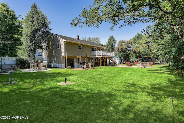 view of yard featuring stairway, a patio area, fence, a deck, and a fire pit