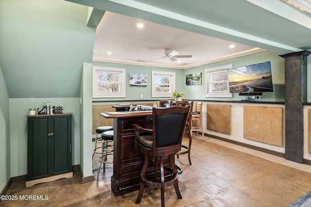 bar featuring recessed lighting, ornamental molding, ceiling fan, a bar, and concrete floors