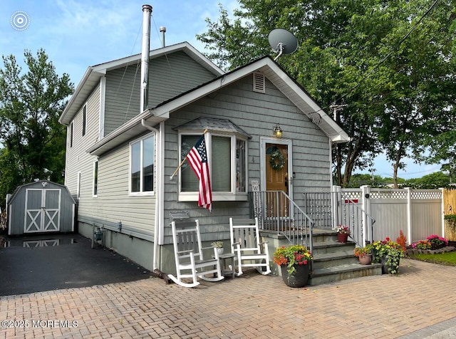 view of front of home featuring a patio area and a storage unit