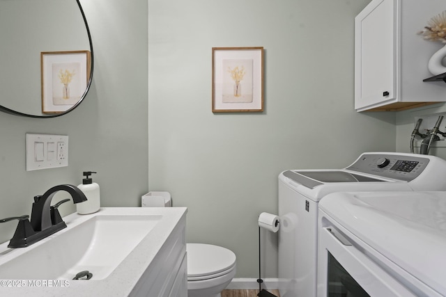 bathroom with vanity, toilet, and washing machine and dryer