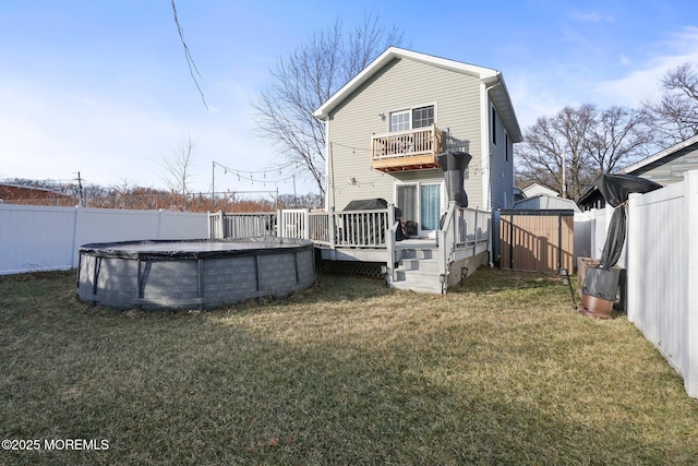 rear view of house with a pool side deck and a lawn