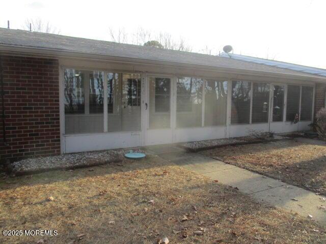 rear view of house featuring a sunroom