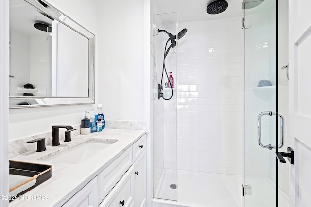 bathroom featuring vanity and a shower with door