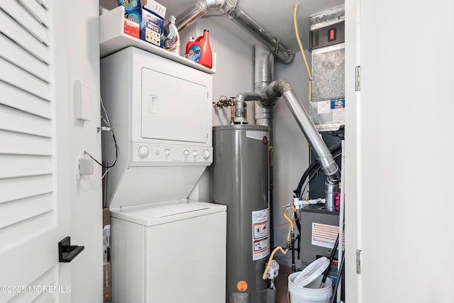 washroom featuring stacked washer / drying machine and water heater