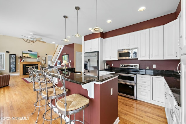 kitchen with decorative light fixtures, sink, a breakfast bar area, a center island, and stainless steel appliances