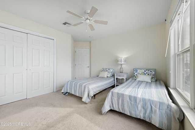 carpeted bedroom with ceiling fan and a closet