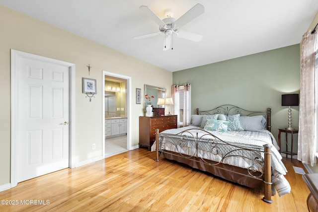 bedroom featuring ceiling fan, ensuite bath, and light hardwood / wood-style flooring