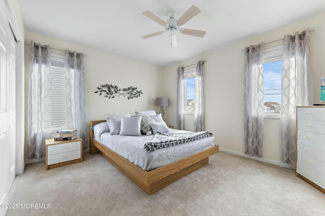 bedroom featuring ceiling fan, a closet, and light carpet