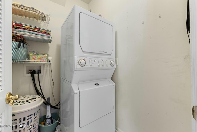 clothes washing area with stacked washer / dryer