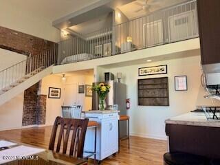 interior space with a towering ceiling, baseboards, and wood finished floors