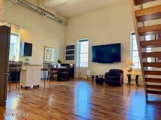 living room featuring wood finished floors and a towering ceiling