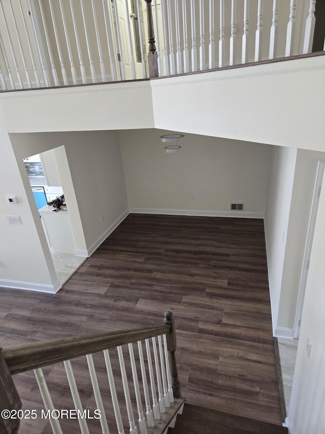 stairway featuring a high ceiling and hardwood / wood-style floors