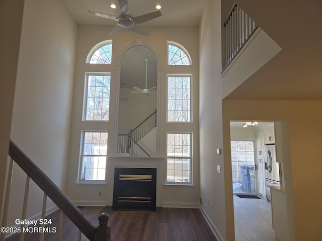 interior space with ceiling fan, plenty of natural light, and a towering ceiling