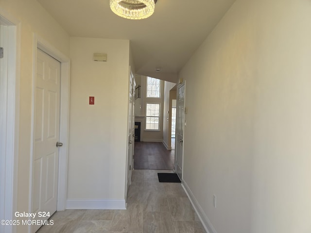 hall with an inviting chandelier