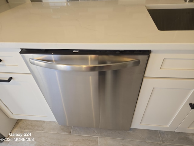 room details featuring white cabinetry, stainless steel dishwasher, and sink