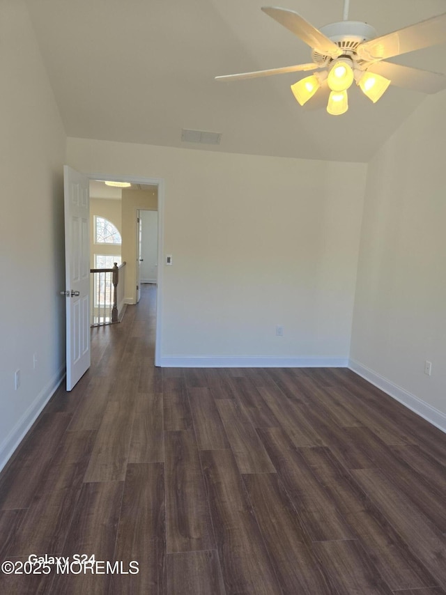 empty room with ceiling fan and dark hardwood / wood-style flooring