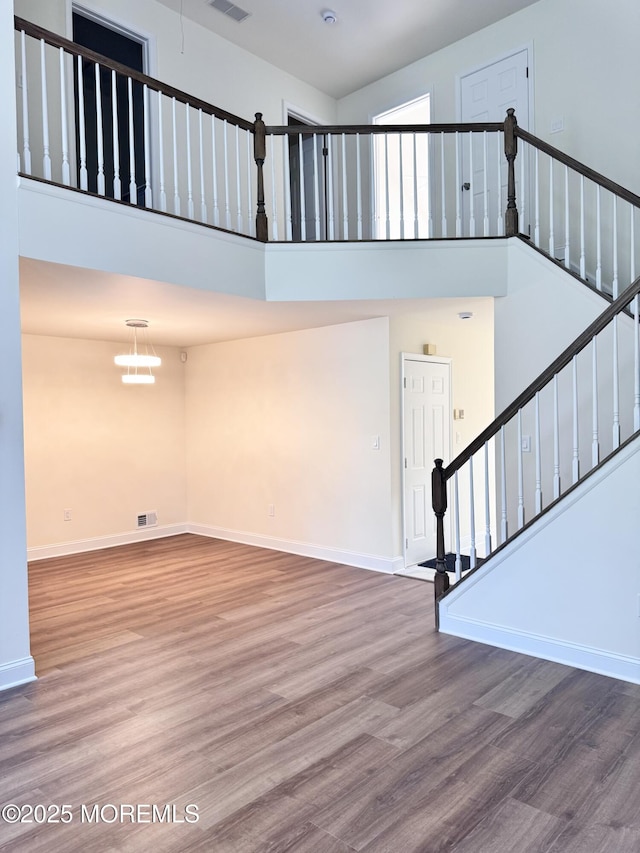 327 Daniele Dr, Ocean Twp, NJ 07712 - unfurnished living room with a high ceiling, wood finished floors, and stairway