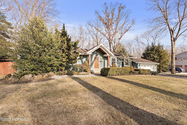 view of front of property featuring a front lawn, an attached garage, and fence