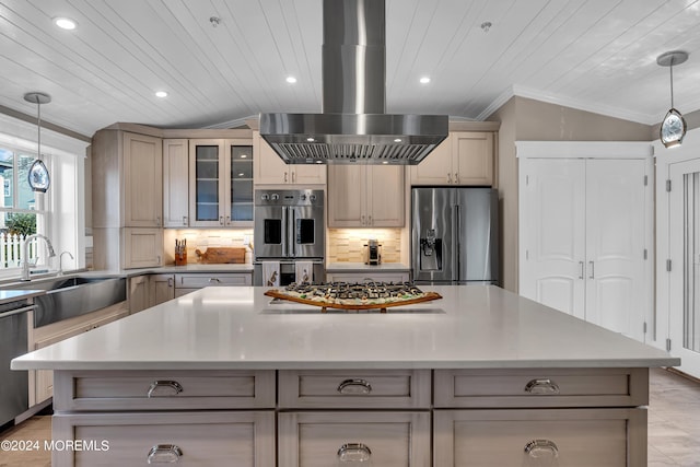 kitchen with appliances with stainless steel finishes, pendant lighting, island range hood, sink, and decorative backsplash