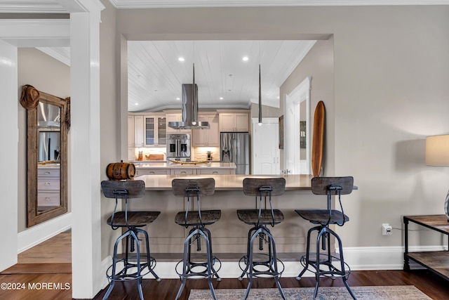 kitchen with dark wood-type flooring, fridge, a kitchen breakfast bar, island range hood, and stainless steel fridge with ice dispenser