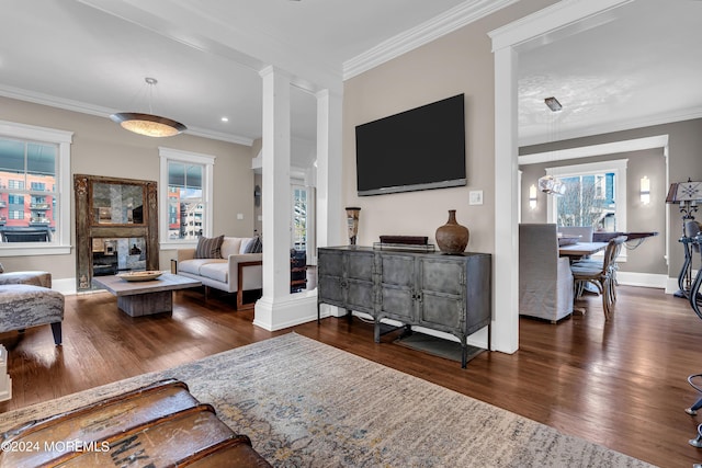 living room featuring ornate columns, ornamental molding, dark hardwood / wood-style floors, and a fireplace