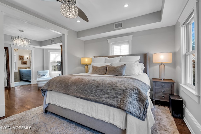 bedroom featuring ceiling fan with notable chandelier and dark wood-type flooring