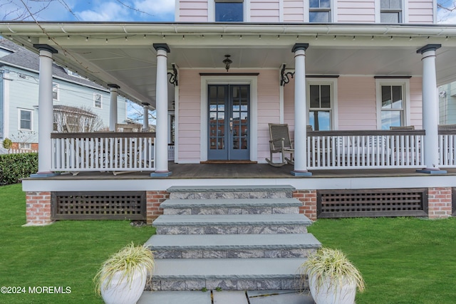 doorway to property featuring a yard and a porch