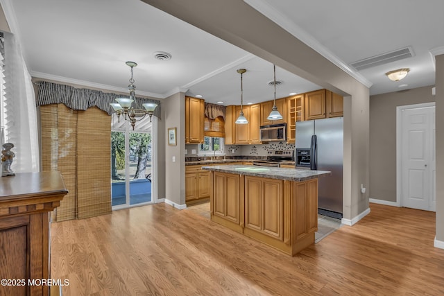 kitchen featuring pendant lighting, light hardwood / wood-style flooring, appliances with stainless steel finishes, a kitchen island, and stone countertops